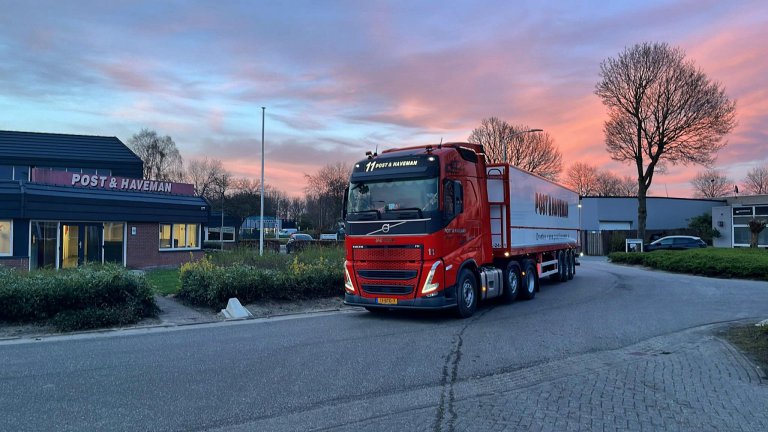 Truck van Post & Haveman voor het kantoor in het roze avondlicht