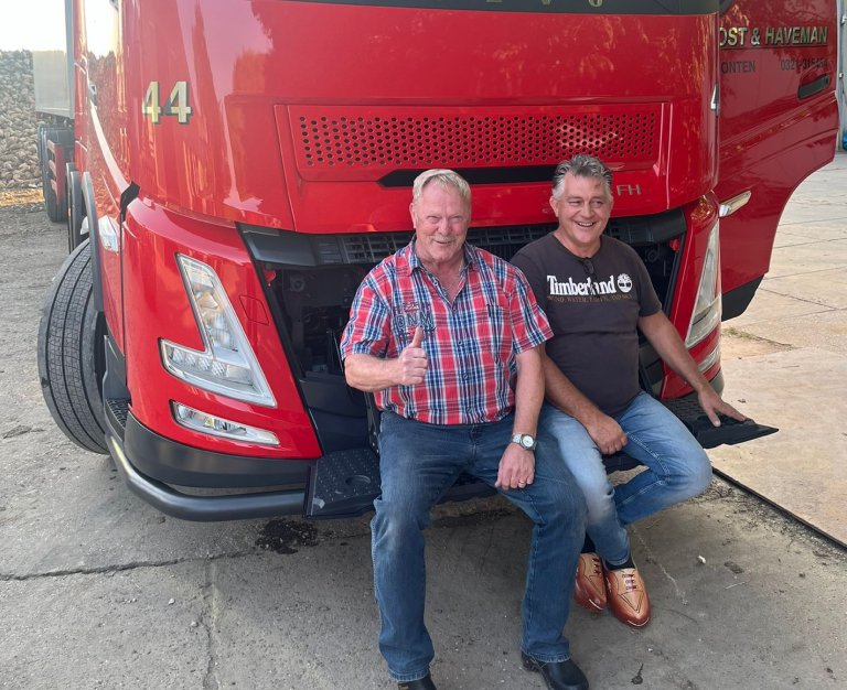 Twee chauffeurs voor een rode vrachtwagen van Post & Haveman